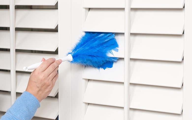 Cleaning closed wooden shutters in a home
