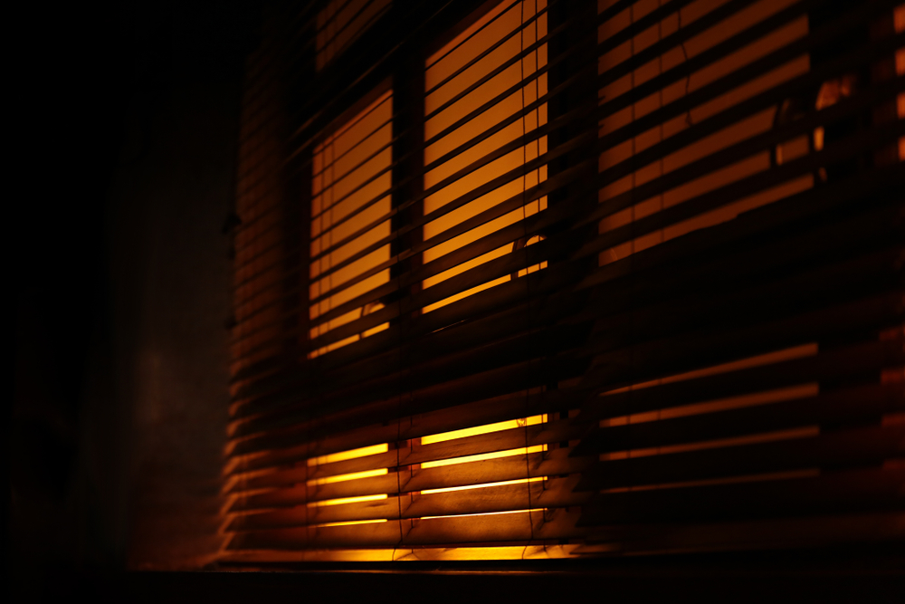 Blinds for a better night's sleep: Venetian blinds allowing a small amount of light into a room