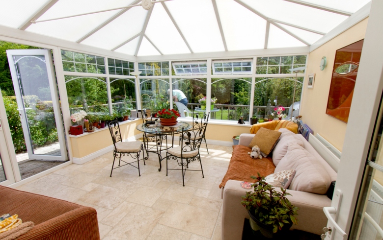 Conservatory in summer with indoor plants and dining table