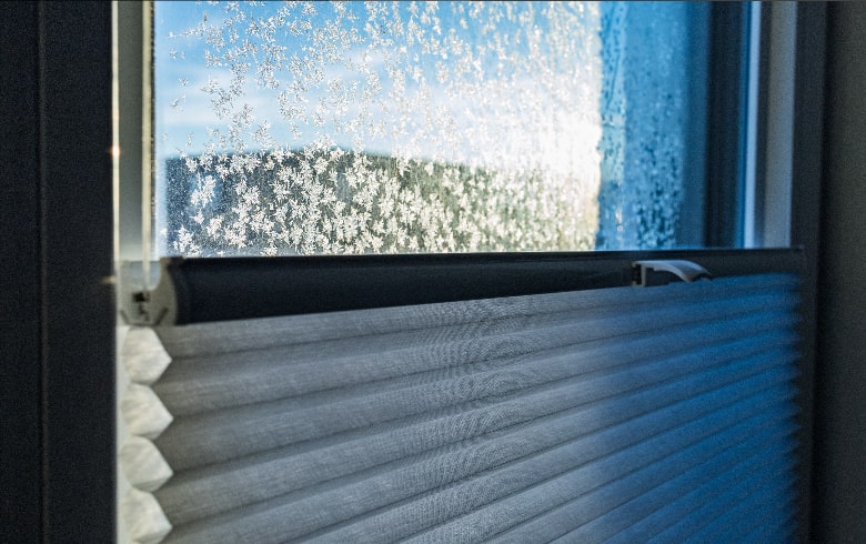 pleated blinds against a frosted window 