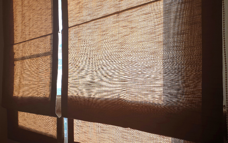 Double brown fabric Roman blinds helps prevent sunlight from entering a room.